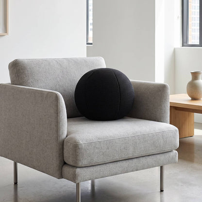 Black Ball Cushion 30cm styled on modern grey armchair in living room