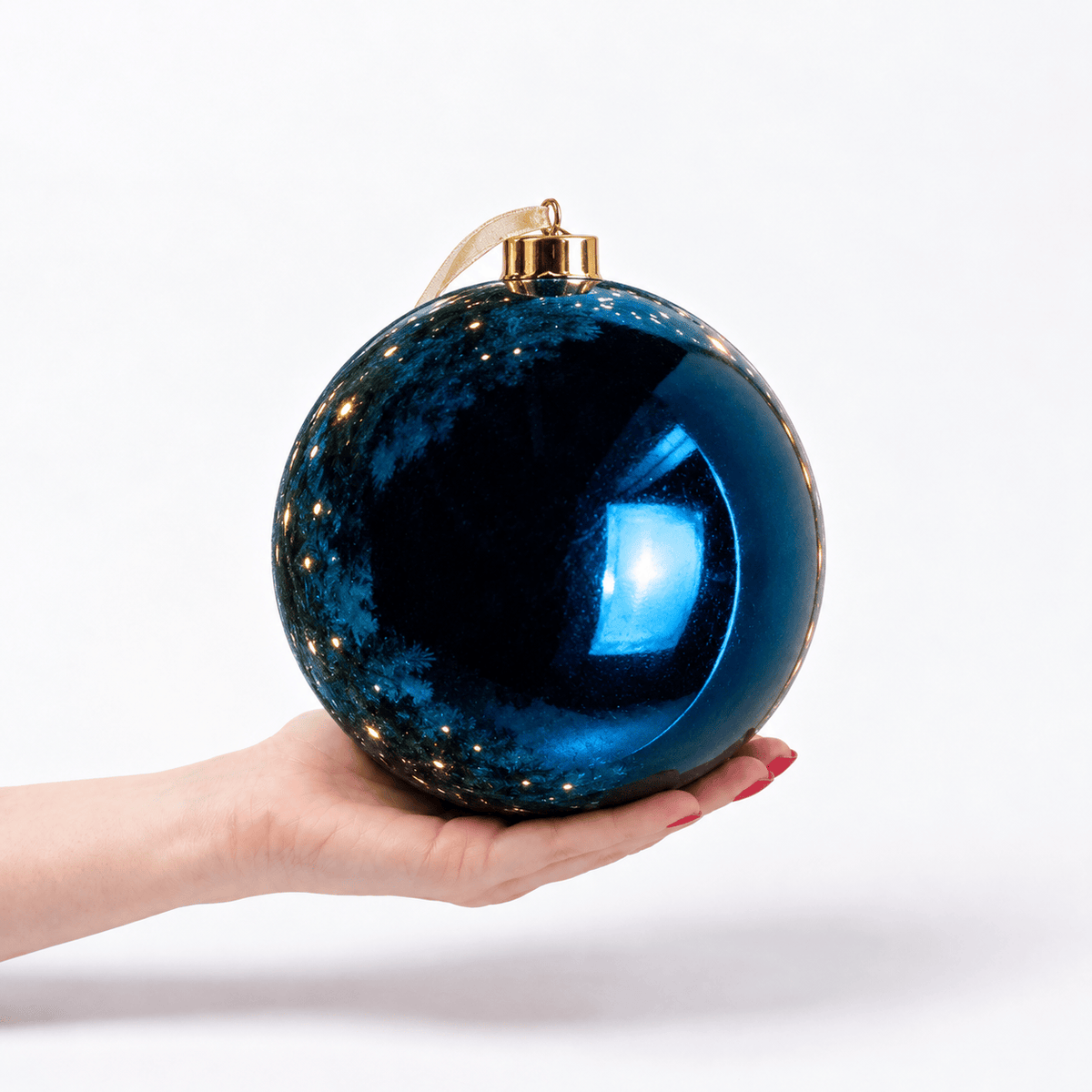 Blue Shiny Large Bauble – 20cm, oversized metallic blue Christmas bauble resting in a hand to demonstrate its 25cm diameter, featuring a high-shine reflective finish and gold hanging cap.