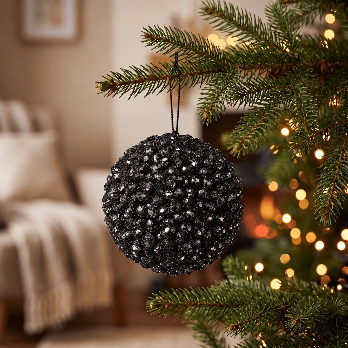 Foam Cluster Bauble - Black Glitter - 15cm, hanging on a Christmas tree with warm white fairy lights, featuring sparkling black clusters and reflective glitter detailing.