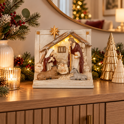17cm Open Book Nativity Scene Christmas decoration featuring Mary, Joseph, baby Jesus and animals in an illuminated stable, displayed on a festive sideboard.