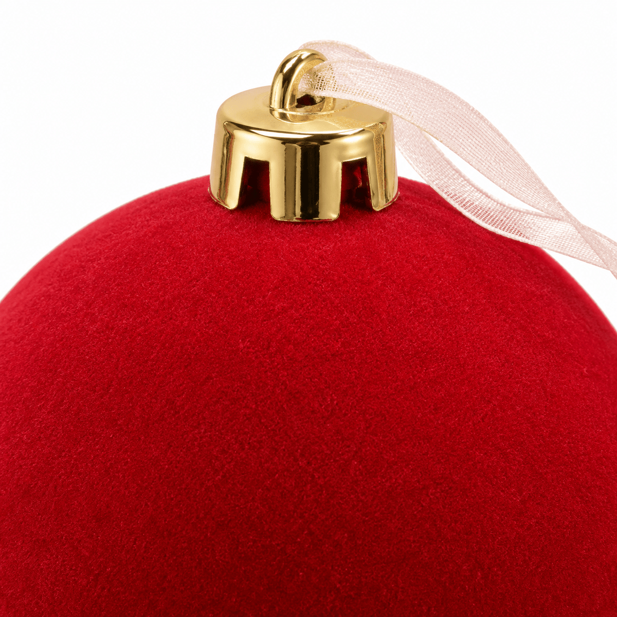Close-up of red velvet Christmas bauble featuring soft fabric texture, shiny gold hanging cap and delicate sheer ribbon.